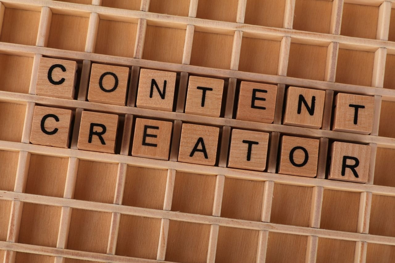 Home Wooden block letters spelling 'Content Creator' on a grid background. Ideal for digital marketing themes.