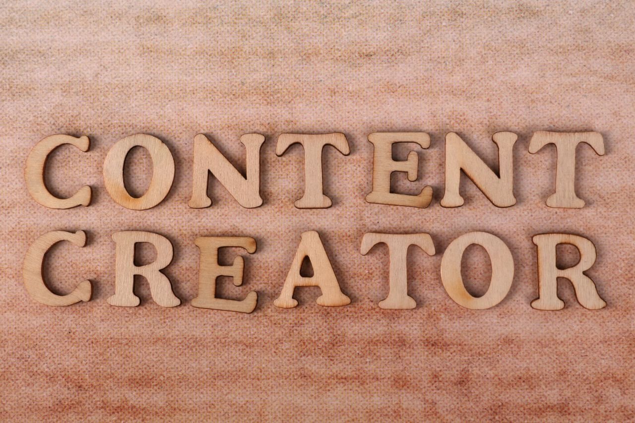 Home Wooden letters form 'Content Creator' on textured fabric background.
