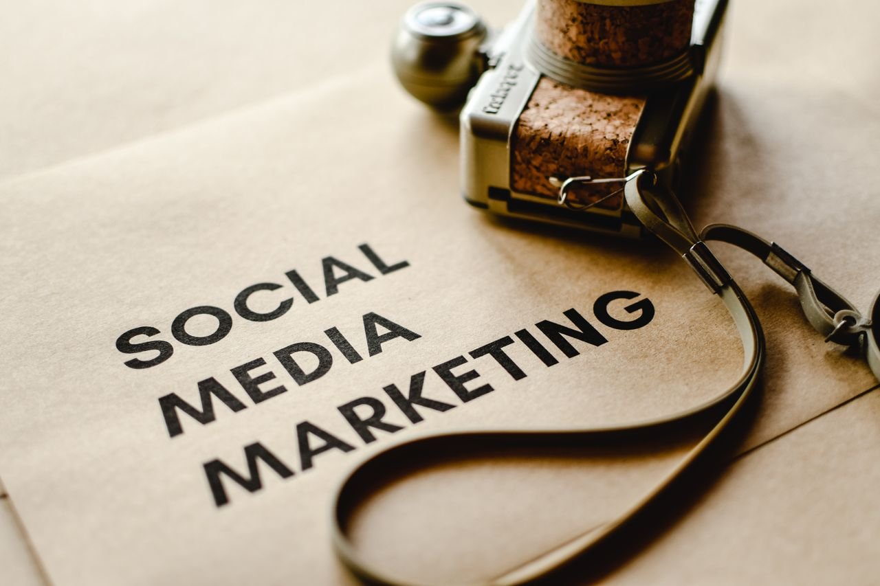 Home Close-up of a camera placed on brown paper with 'Social Media Marketing' text, emphasizing digital marketing themes.
