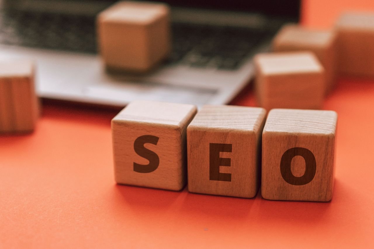Home Wooden blocks spelling SEO on a laptop keyboard convey digital marketing concepts.